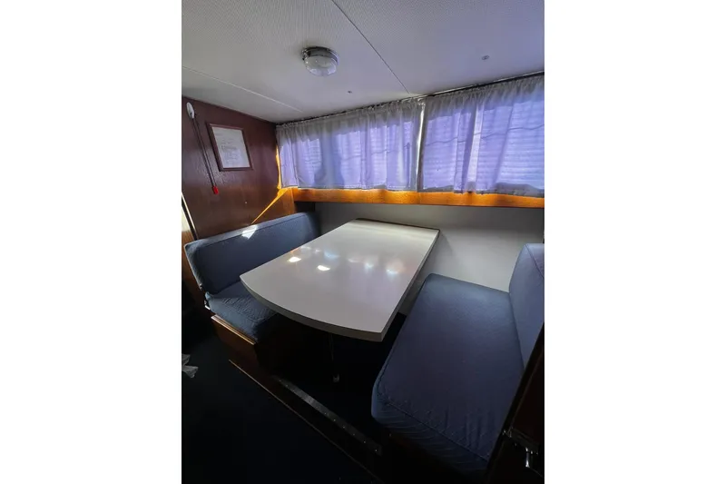 Slide: The Image of 1967 Chris-Craft 31 Commander interior dining area with table and cushioned seating. - 26