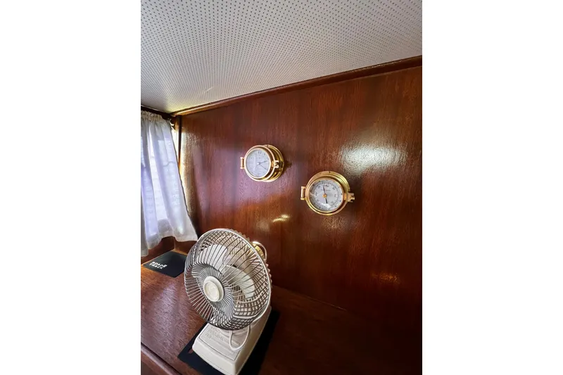 Slide: The Image of 1967 Chris-Craft 31 Commander interior with fan, brass instruments, and wood paneling. - 28