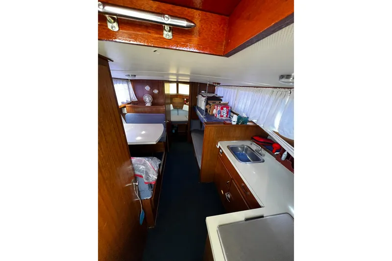 Slide: The Image of Interior of a 1967 Chris-Craft 31 Commander boat, featuring a compact kitchen and dining area. - 36