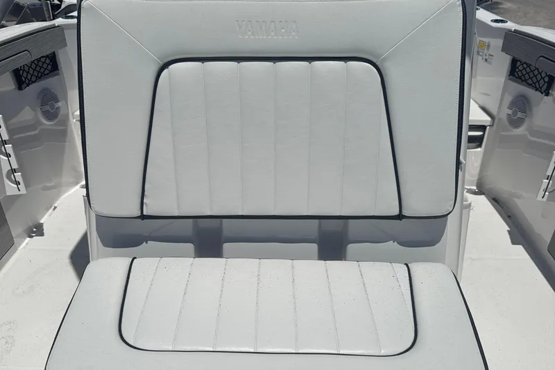 Slide: The Image of 2026 Yamaha Boats 220 FSH Sport interior seating, featuring white cushioned upholstery. - 12