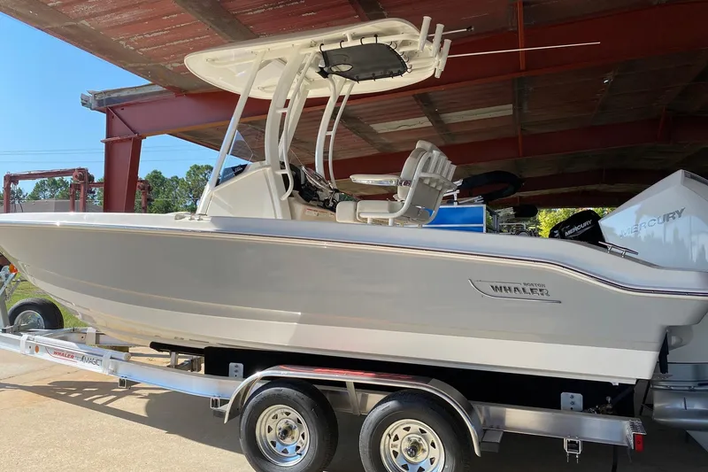 The Image of 2026 Boston Whaler 220 Dauntless boat on trailer under metal roof. - 0