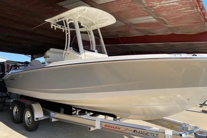 Slide: The Image of 2026 Boston Whaler 220 Dauntless boat on trailer under shelter. - 1