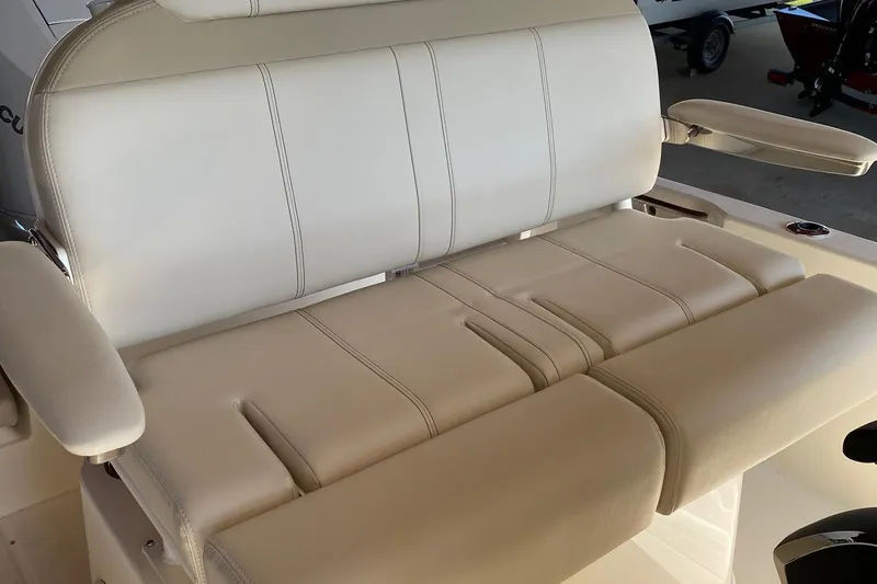 Slide: The Image of 2026 Boston Whaler 220 Dauntless boat seat with beige upholstery and armrests. - 11
