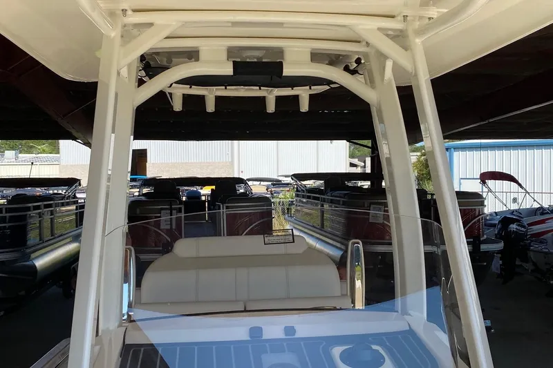 Slide: The Image of 2026 Boston Whaler 220 Dauntless boat interior with seating and console, in a showroom. - 12