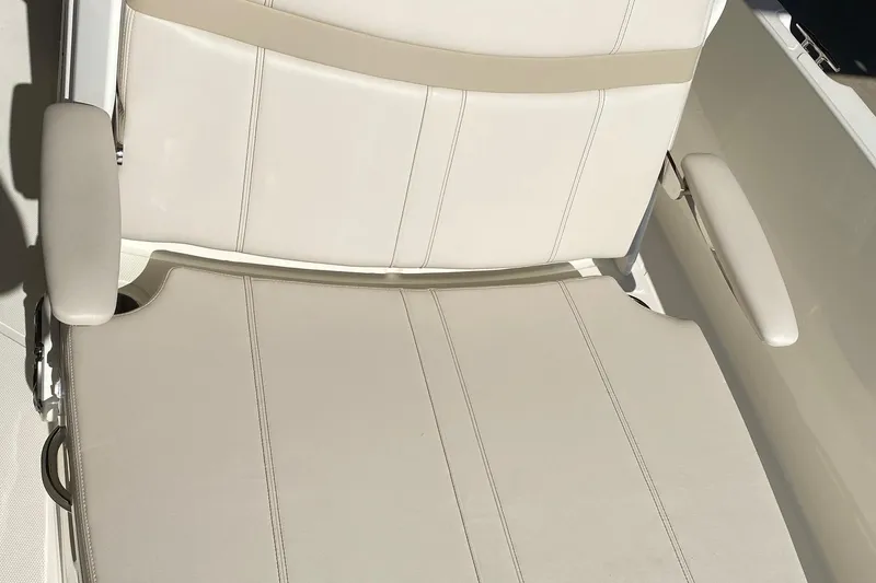 Slide: The Image of 2026 Boston Whaler 220 Dauntless boat seat with beige upholstery and armrests. - 13