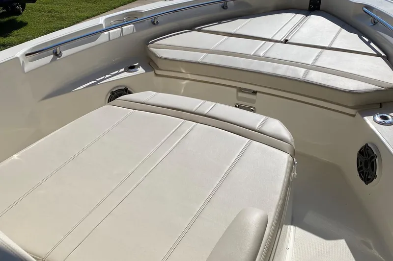 Slide: The Image of 2026 Boston Whaler 220 Dauntless boat interior with cushioned seating and stainless steel railings. - 14