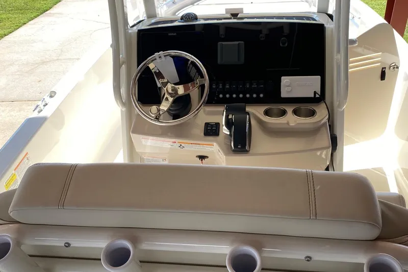 Slide: The Image of 2026 Boston Whaler 220 Dauntless boat console with steering wheel and controls. - 2