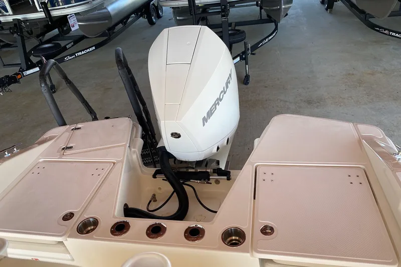 Slide: The Image of 2026 Boston Whaler 220 Dauntless with Mercury outboard engine, showcased in a showroom. - 7