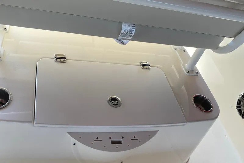 Slide: The Image of 2026 Boston Whaler 220 Dauntless boat interior with storage compartment and cup holders. - 8