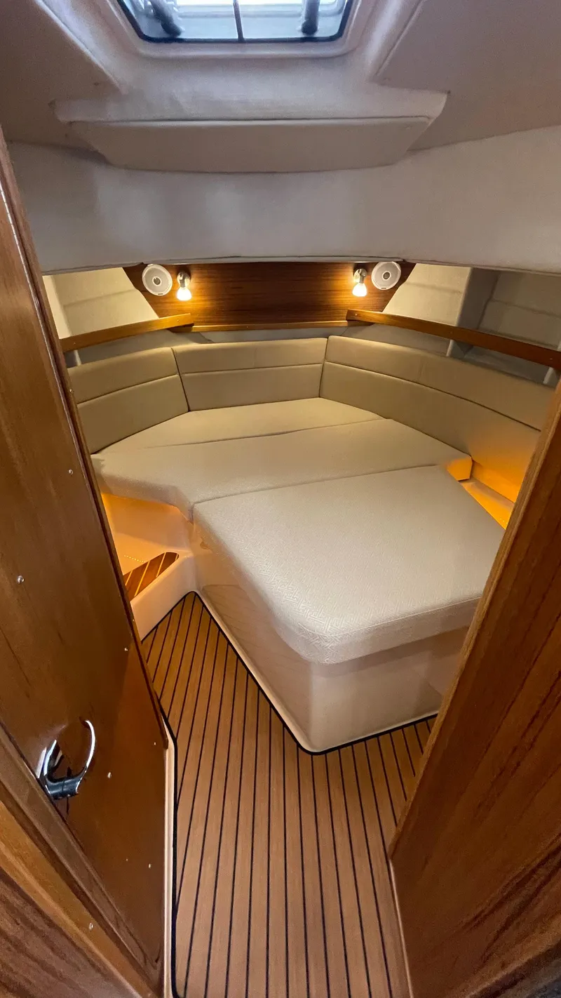 Slide: The Image of 2023 Ranger Tugs R-31 CB interior kitchen with stove, sink, and wood finish. - 17