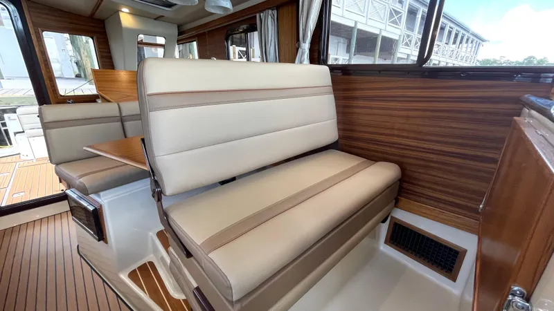 Slide: The Image of 2023 Ranger Tugs R-31 CB cabin interior with wood paneling and mounted TV. - 19