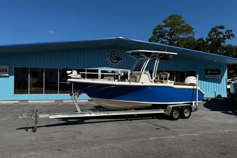 The Image of 2018 Key West 239 FS boat on trailer outside blue building under clear sky. - 0