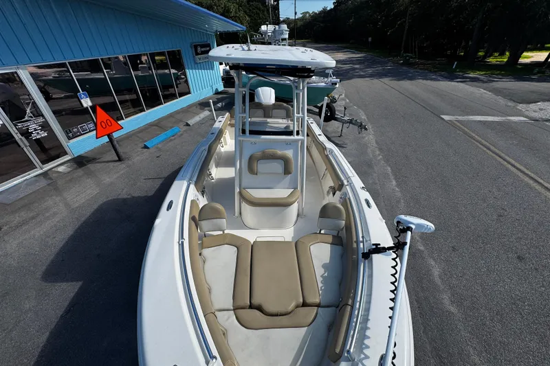 Slide: The Image of 2018 Key West 239 FS boat with beige seating, parked near a blue building. - 10