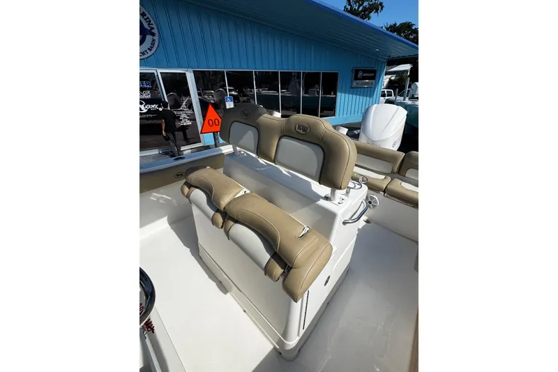 Slide: The Image of 2018 Key West 239 FS boat interior with tan seating and blue building background. - 12
