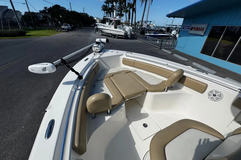 Slide: The Image of 2018 Key West 239 FS boat with tan seating and trolling motor, dockside view. - 18