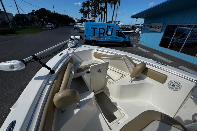 Slide: The Image of 2018 Key West 239 FS boat interior with seating and storage, parked near a blue building. - 19