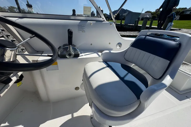 Slide: The Image of Interior of 2000 World Cat 246 DC boat with steering wheel and cushioned seat. - 11