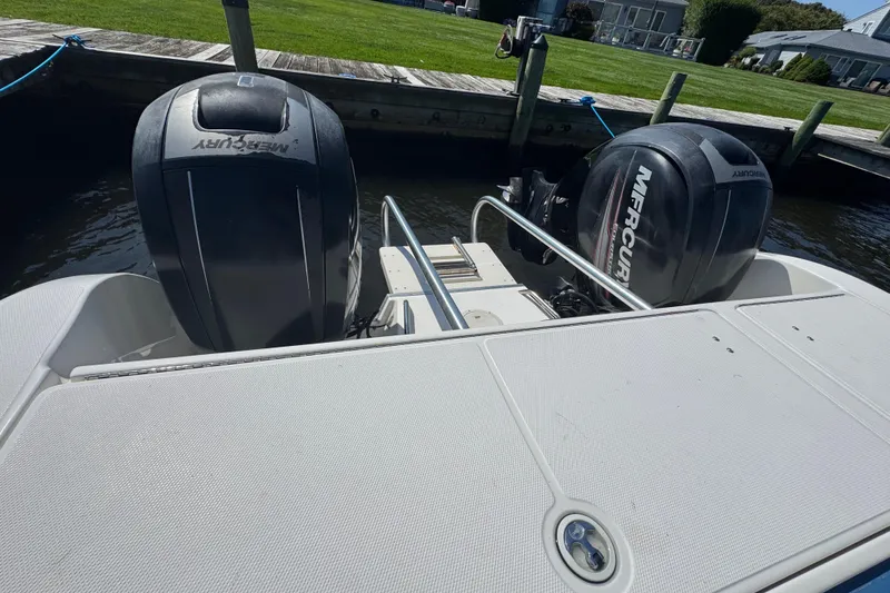 Slide: The Image of World Cat 246 DC boat with dual Mercury outboard engines docked by the water. - 19