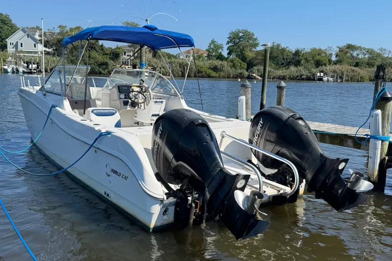 Slide: The Image of 2000 World Cat 246 DC boat with dual Mercury engines docked on a sunny day. - 5
