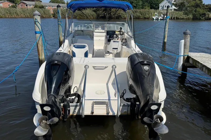 Slide: The Image of World Cat 246 DC 2000 boat docked with dual outboard motors and blue canopy. - 6