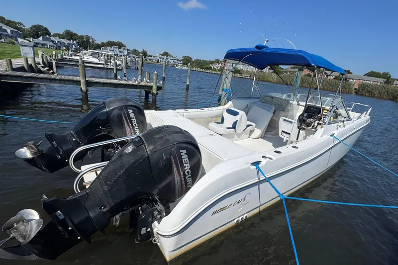 Slide: The Image of 2000 World Cat 246 DC boat with dual Mercury engines docked on a sunny day. - 7