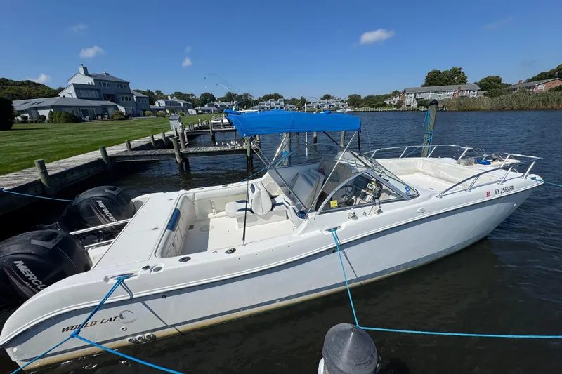 Slide: The Image of 2000 World Cat 246 DC boat docked by waterfront homes under clear blue sky. - 8