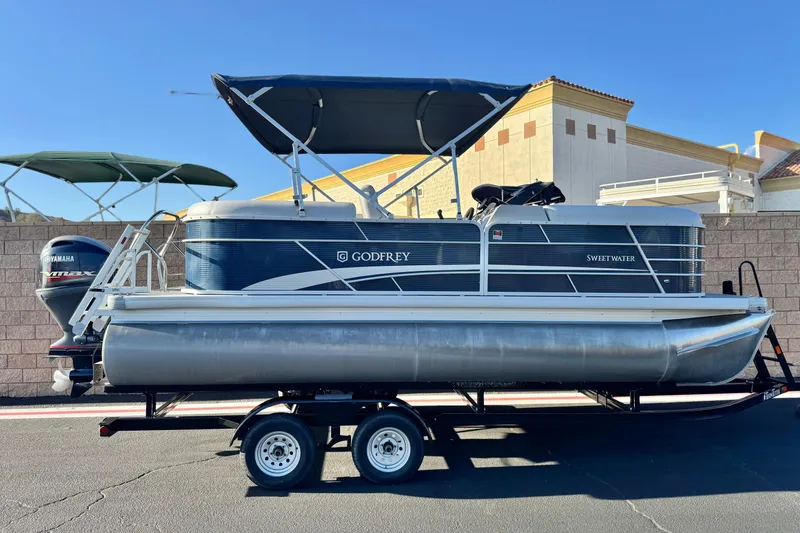 The Image of 2022 Godfrey SWEETWATER 2086 pontoon boat on trailer, featuring Yamaha outboard motor. - 0