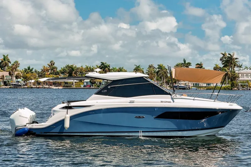 The Image of 2022 Sea Ray Sundancer 320 Outboard cruising on a sunny day with palm trees in the background. - 1