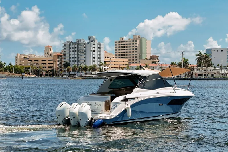 Slide: The Image of 2022 Sea Ray Sundancer 320 Outboard cruising near urban waterfront skyline. - 3