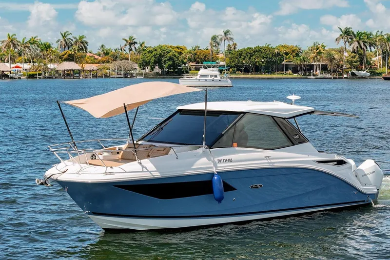 Slide: The Image of 2022 Sea Ray Sundancer 320 Outboard cruising on a sunny day with scenic waterfront views. - 6