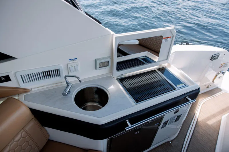 Slide: The Image of 2022 Sea Ray Sundancer 320 Outboard boat kitchenette with sink and grill. - 9