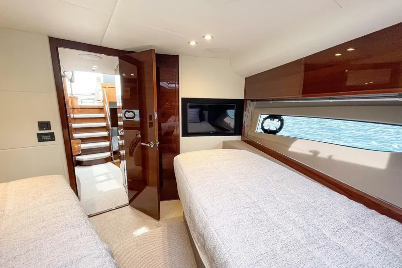 Slide: The Image of Luxurious 2022 Princess V50 yacht cabin with twin beds and elegant wood finishes. - 21