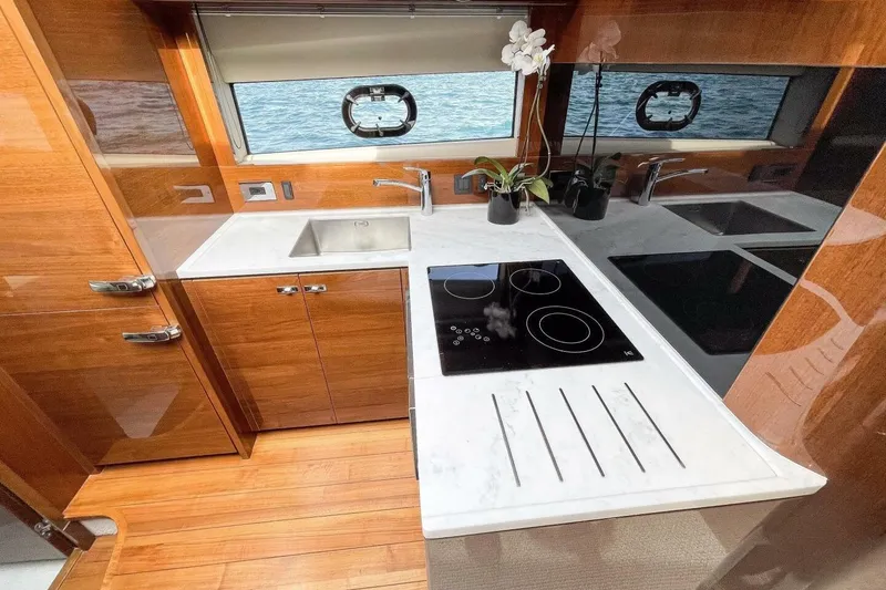 Slide: The Image of Luxurious 2022 Princess V50 yacht kitchen with modern appliances and elegant wood finish. - 23