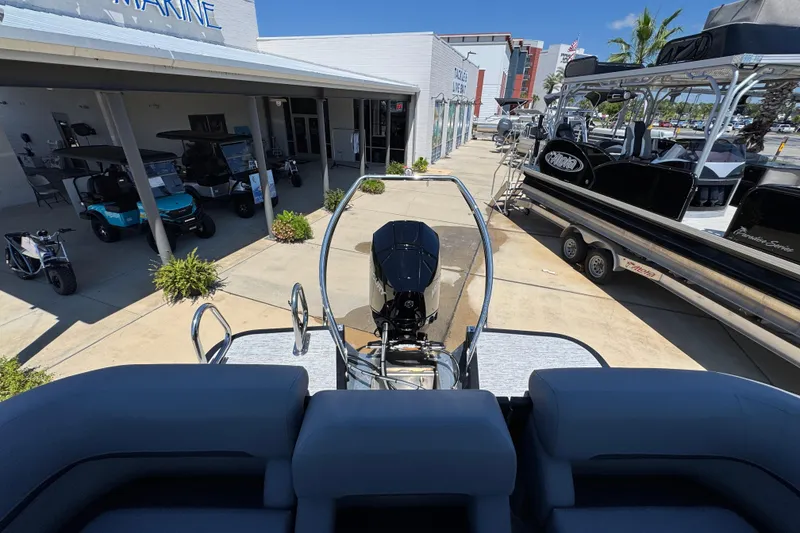 Slide: The Image of 2026 Bennington 22 MFB boat displayed at a marine dealership with other vehicles. - 29