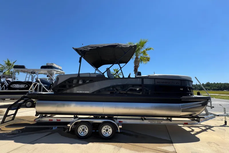 Slide: The Image of 2026 Bennington 22 MFB pontoon boat on trailer under clear blue sky. - 6