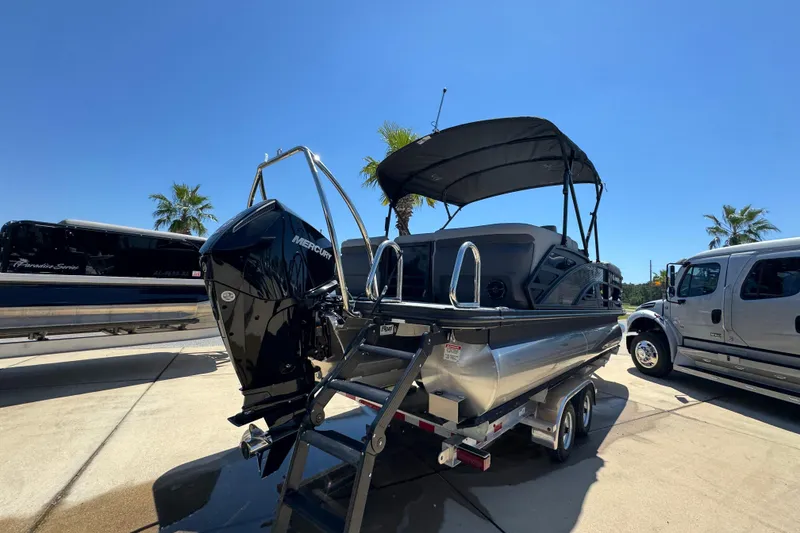 Slide: The Image of 2026 Bennington 22 MFB pontoon boat with Mercury engine on trailer, sunny day. - 9
