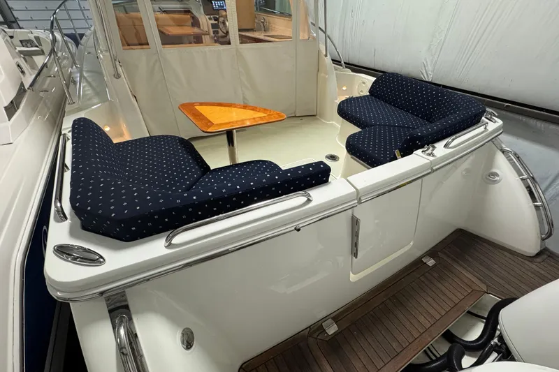 Slide: The Image of 2020 Back Cove 34O boat with cushioned seating and wooden table in cockpit area. - 12