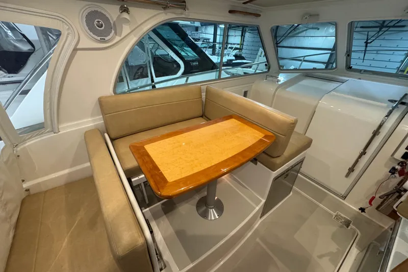 Slide: The Image of Interior of 2020 Back Cove 34O boat with beige seating and wooden table. - 19