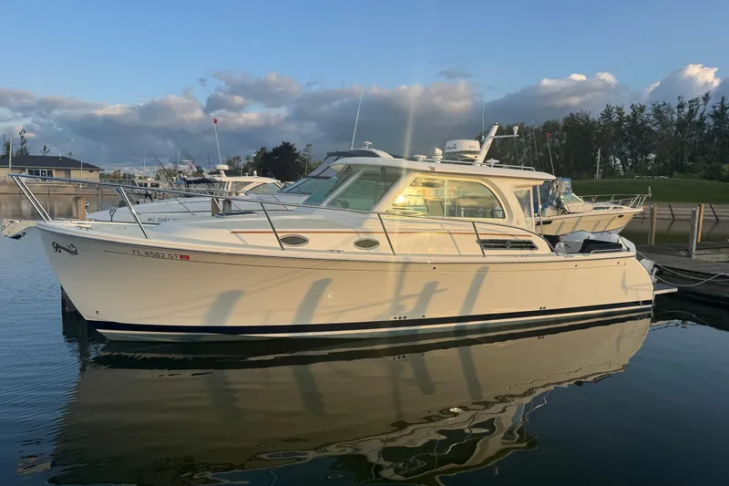 Slide: The Image of 2020 Back Cove 34O boat docked in a serene marina setting. - 2