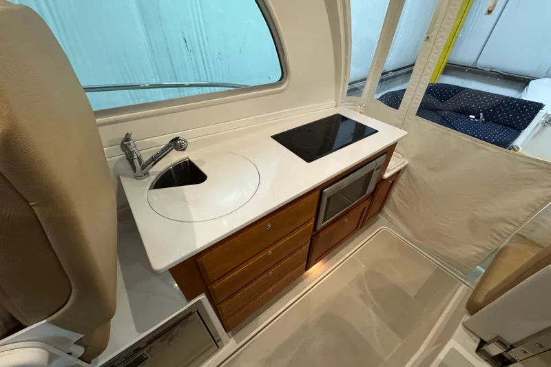Slide: The Image of 2020 Back Cove 34O yacht interior with kitchenette, featuring sink, stove, and microwave. - 21
