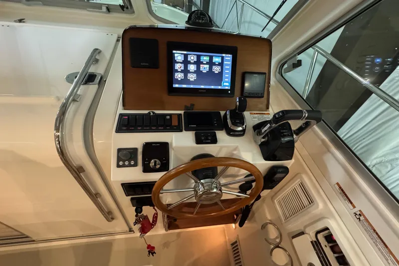Slide: The Image of 2020 Back Cove 34O helm with touchscreen, controls, and wooden steering wheel. - 22