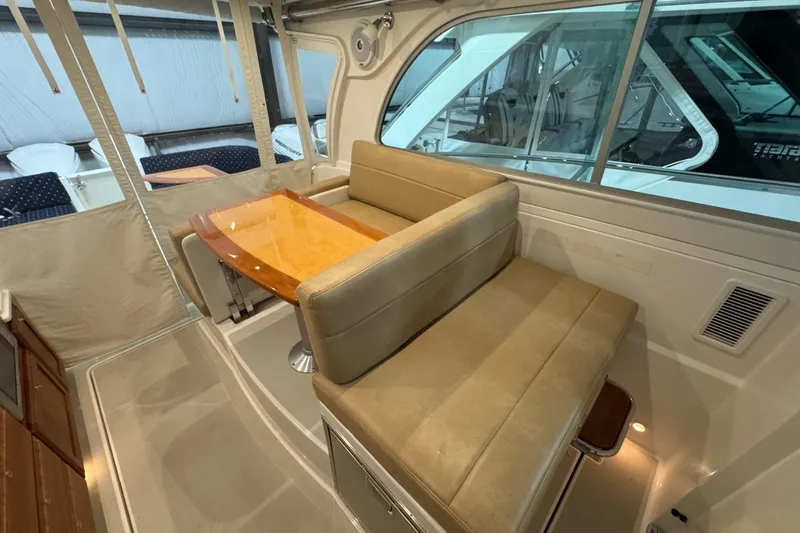 Slide: The Image of 2020 Back Cove 34O interior with beige seating and wooden table in a cozy cabin setting. - 23