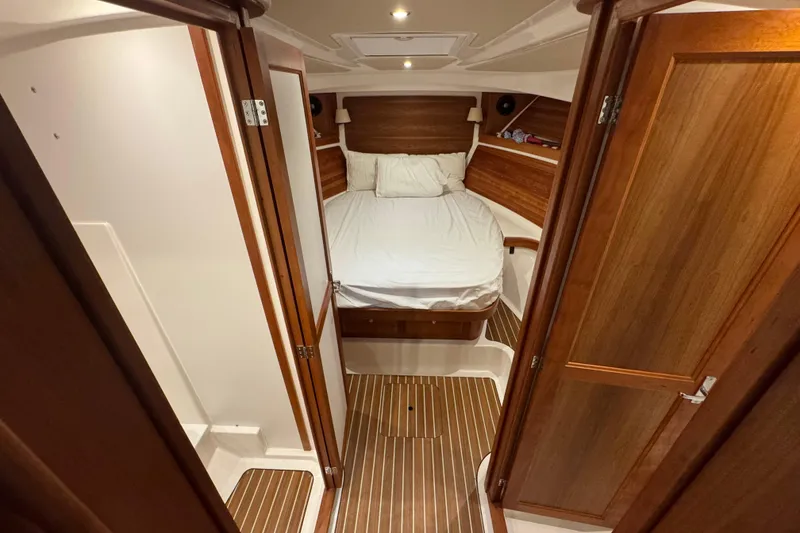 Slide: The Image of 2020 Back Cove 34O cabin interior with wooden finish and cozy bed. - 27