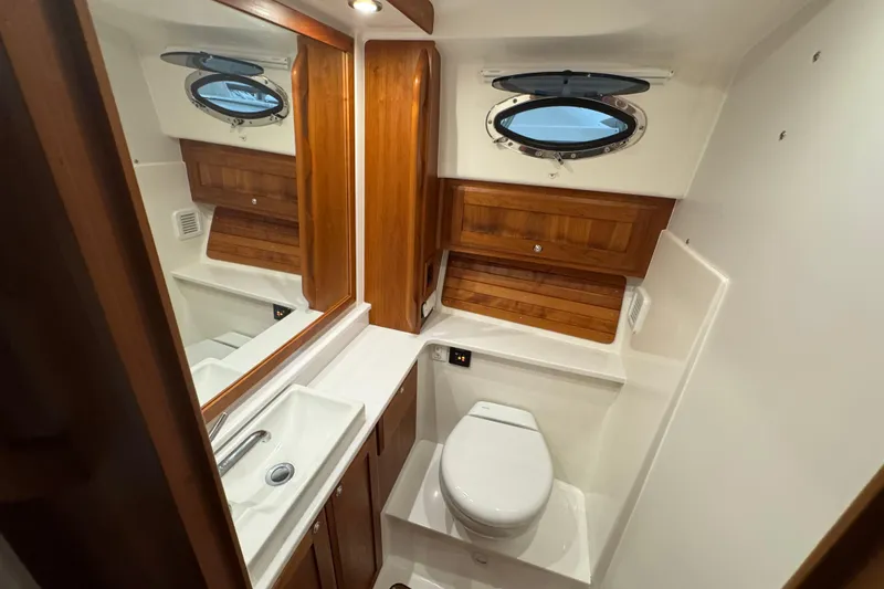Slide: The Image of 2020 Back Cove 34O yacht bathroom with wooden accents and porthole window. - 28
