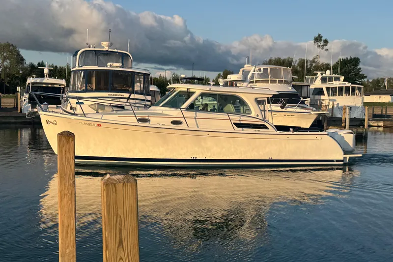 Slide: The Image of 2020 Back Cove 34O yacht docked in a marina, reflecting on calm water. - 3