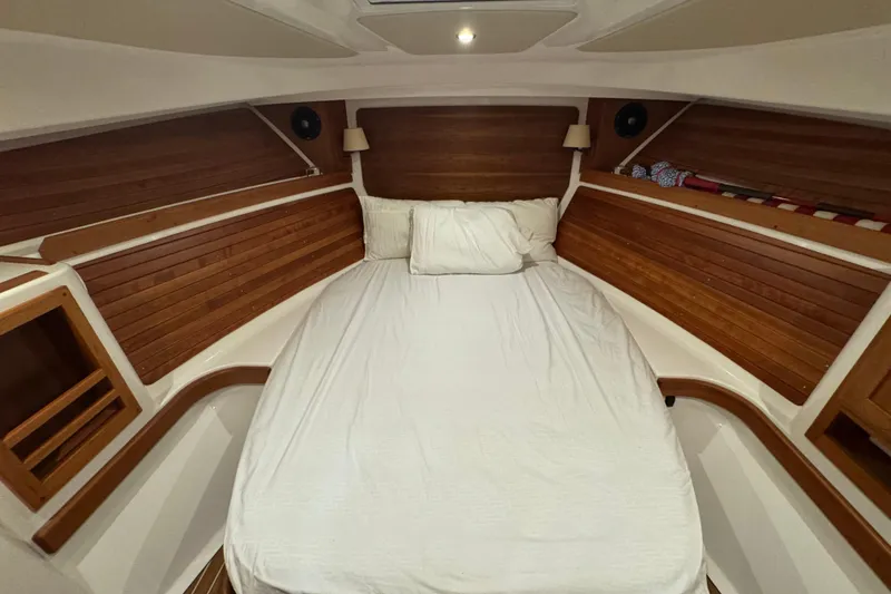 Slide: The Image of 2020 Back Cove 34O cabin interior with cozy bed and wooden paneling. - 32