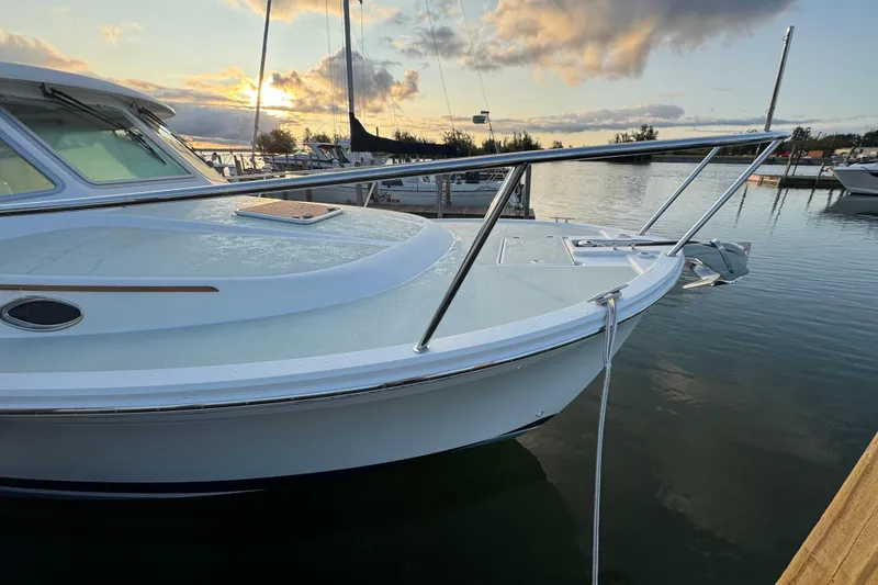 Slide: The Image of 2020 Back Cove 34O boat docked at sunset, featuring sleek design and calm waters. - 5