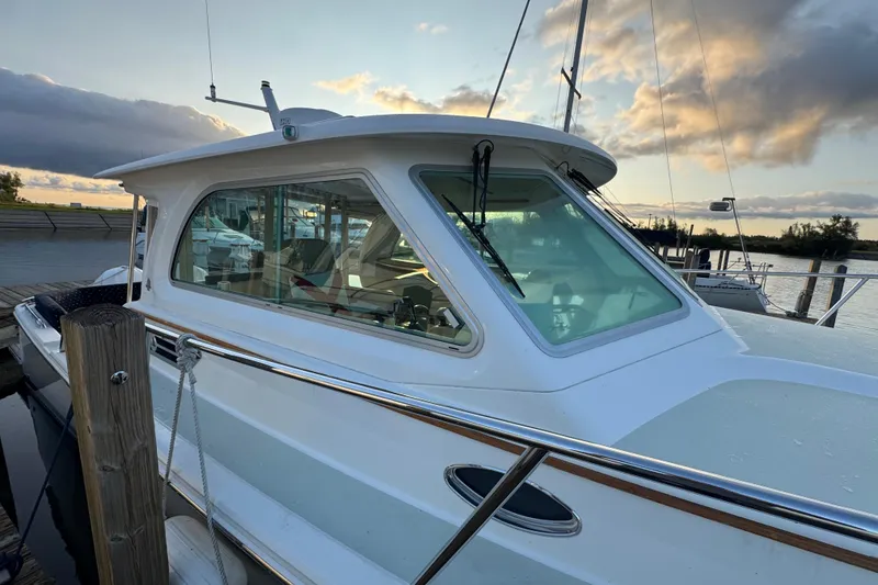 Slide: The Image of 2020 Back Cove 34O boat docked at sunset, showcasing sleek design and windows. - 6