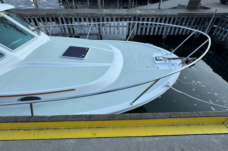 Slide: The Image of 2020 Back Cove 34O boat docked, showcasing sleek bow design and railing. - 8