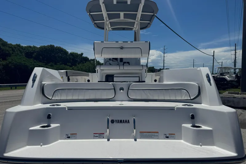 Slide: The Image of 2026 Yamaha Boats 220 FSH Sport, rear view, white seating, outdoor setting. - 2
